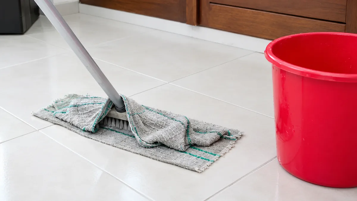 Mop e balde vermelho usados para limpar o chão depois de remover a cera de depilação